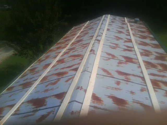 Rusted metal roof panels with new wood purlins before replacement — Storm Damage Roof Repair in Brilliant by Roofing Brothers